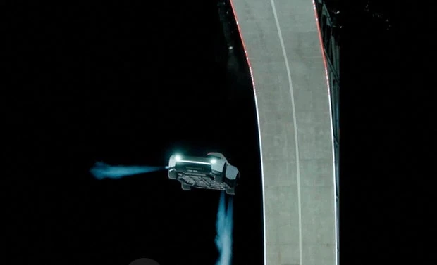 La Tesla Roadster in volo con i getti dei propulsori accanto alla rampa curva