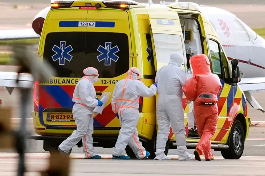 Personale sanitario in tute protettive e ambulanza durante un trasferimento medico collegato al caso MV Hondius