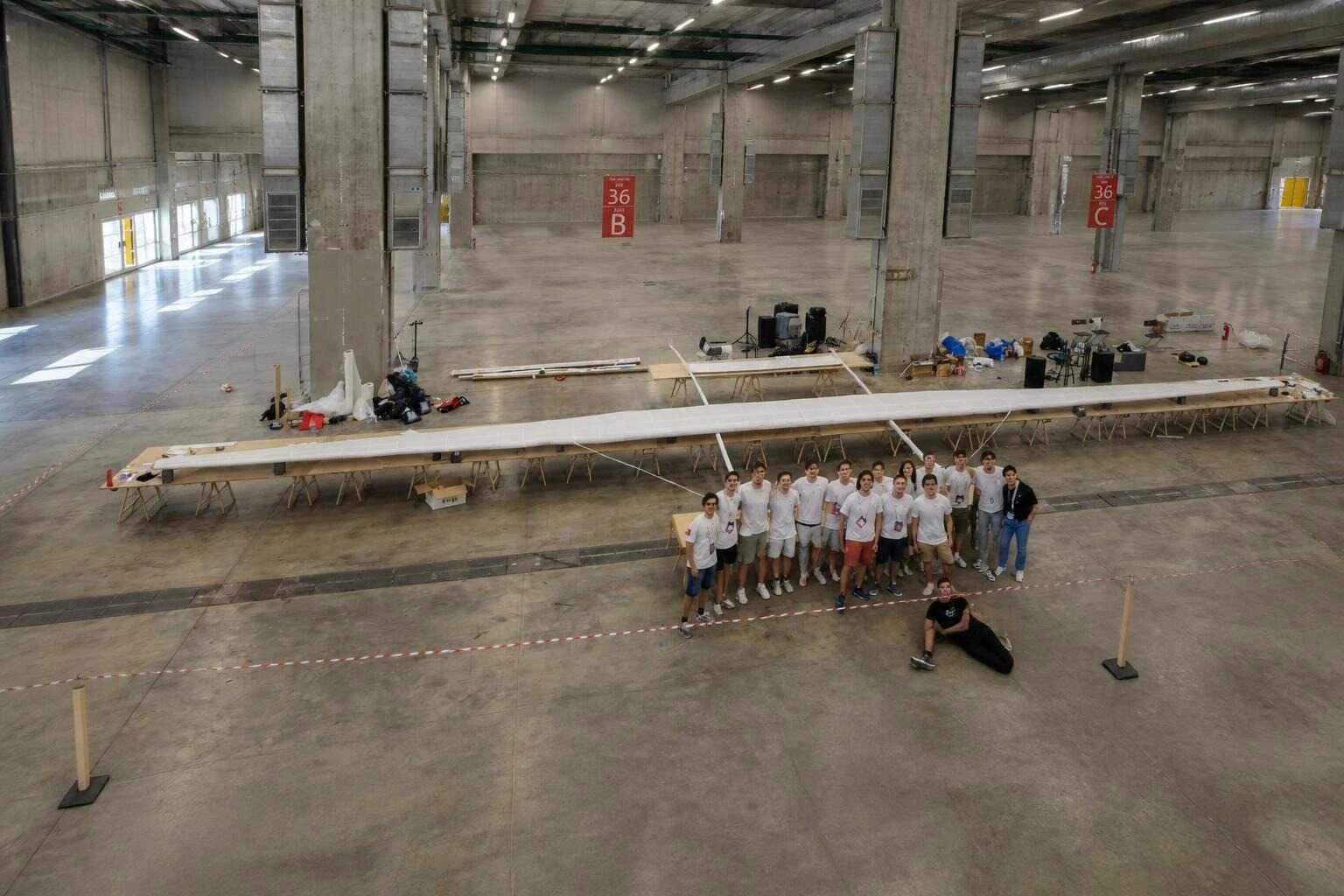 Il team di studenti dell'Universita' di Pisa posa accanto all'aereo di carta Icarus appoggiato sui cavalletti a BolognaFiere
