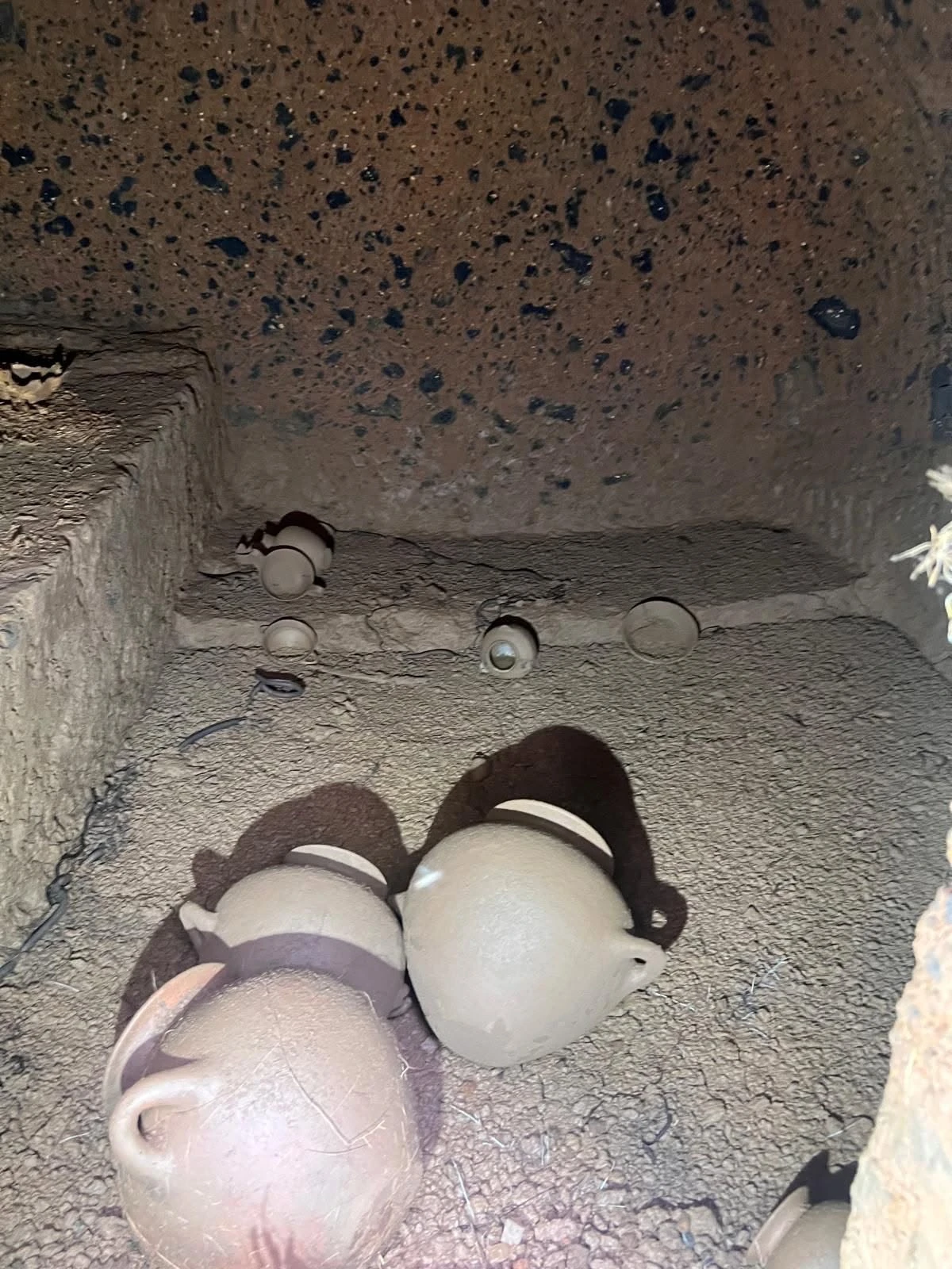 Vasi in ceramica del corredo funebre etrusco ancora disposti nella camera sepolcrale
