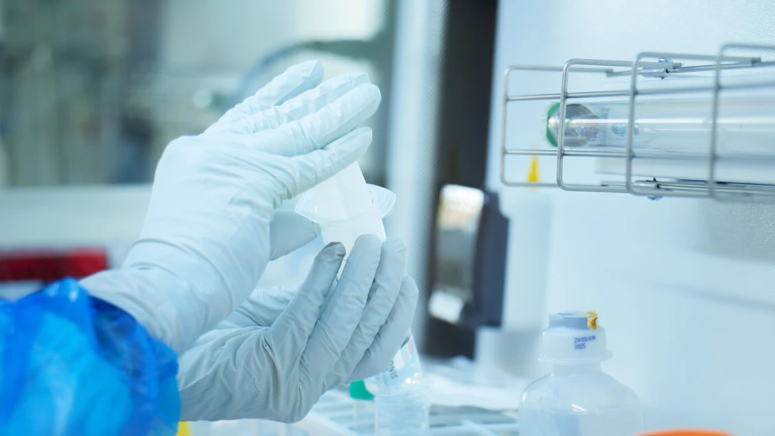 Ricercatore manipola campioni in un laboratorio biomedico sterile