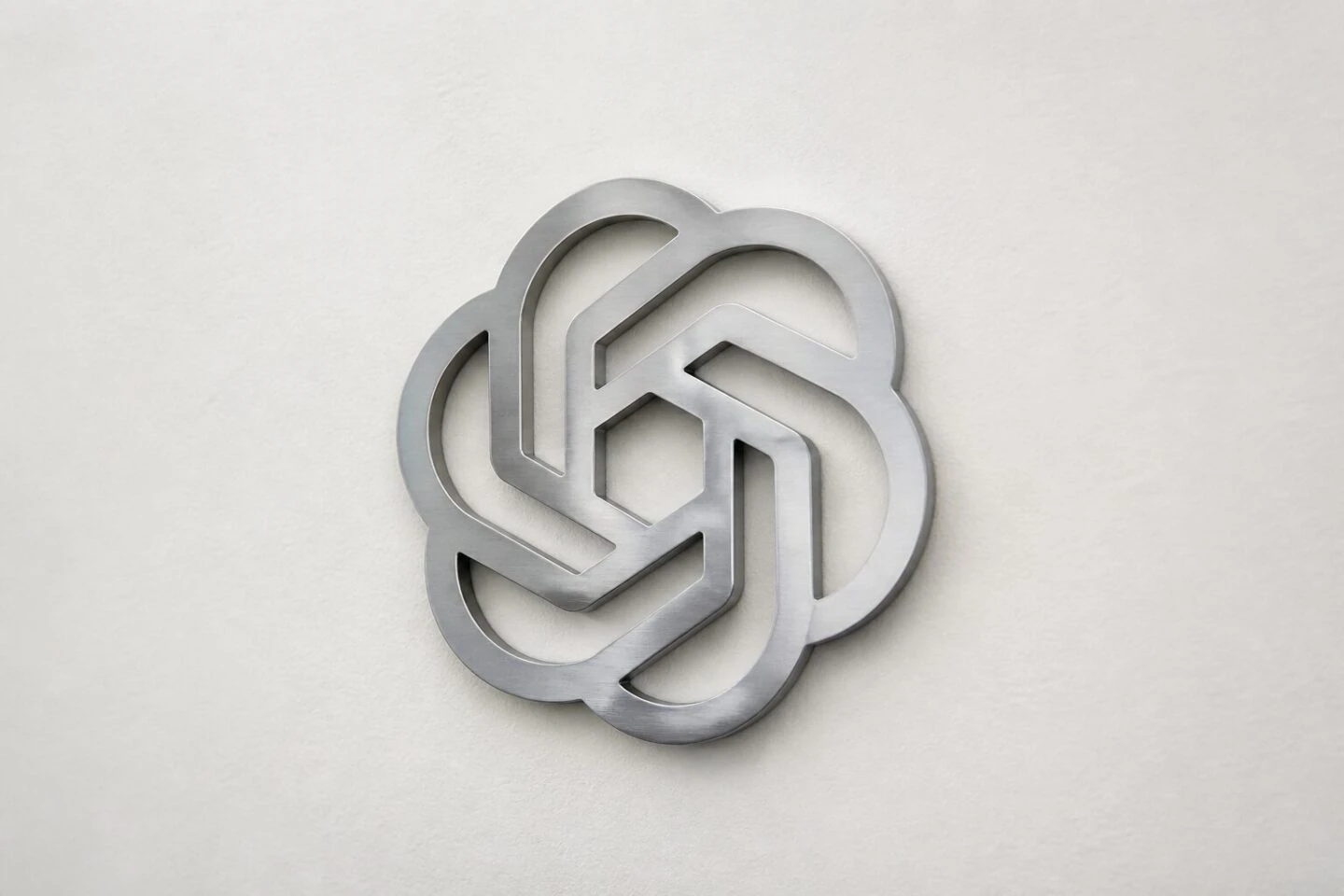 Logo metallico di OpenAI su una parete