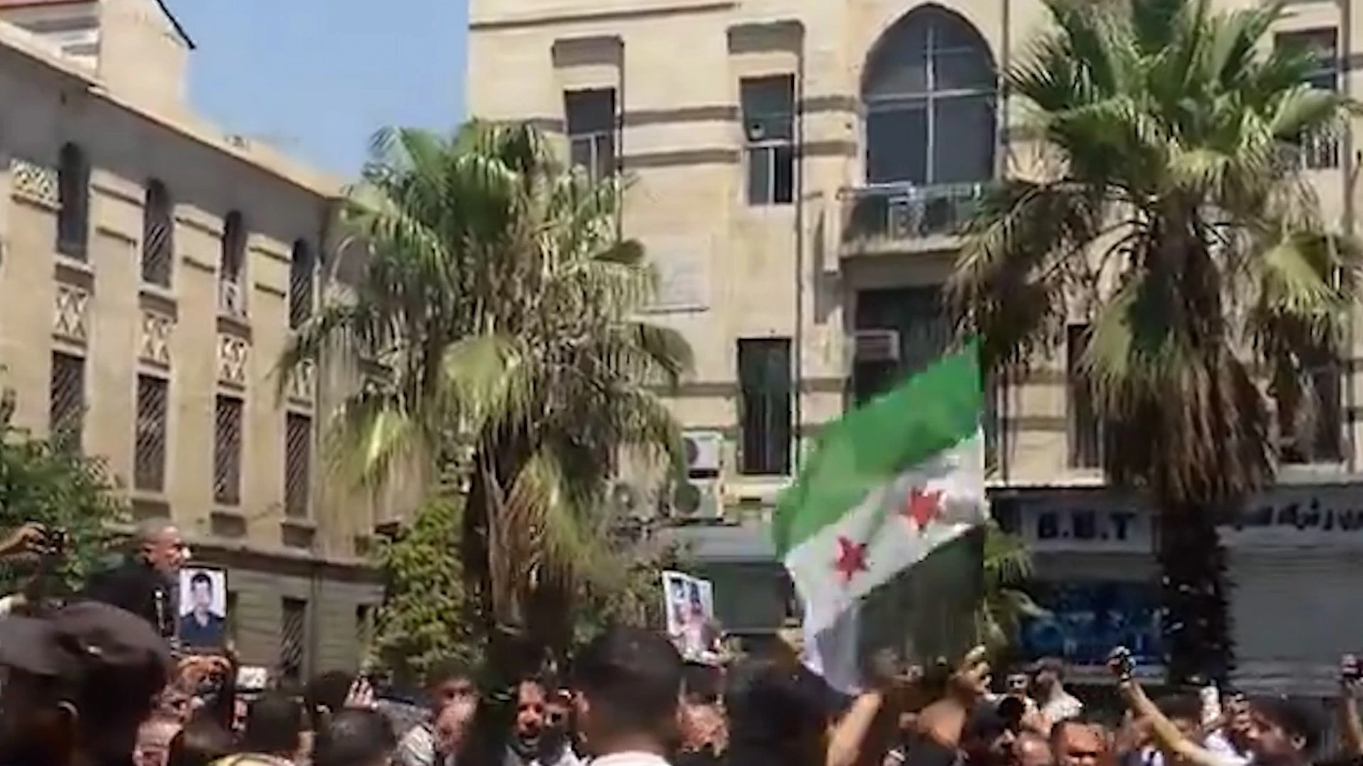 Folla per le strade di Damasco con la bandiera della rivoluzione siriana