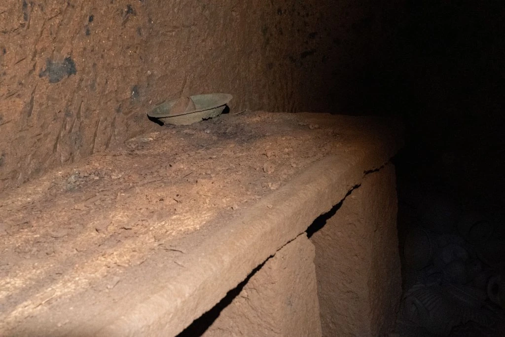 Bacile di bronzo ancora in situ sul letto funebre scavato nel tufo