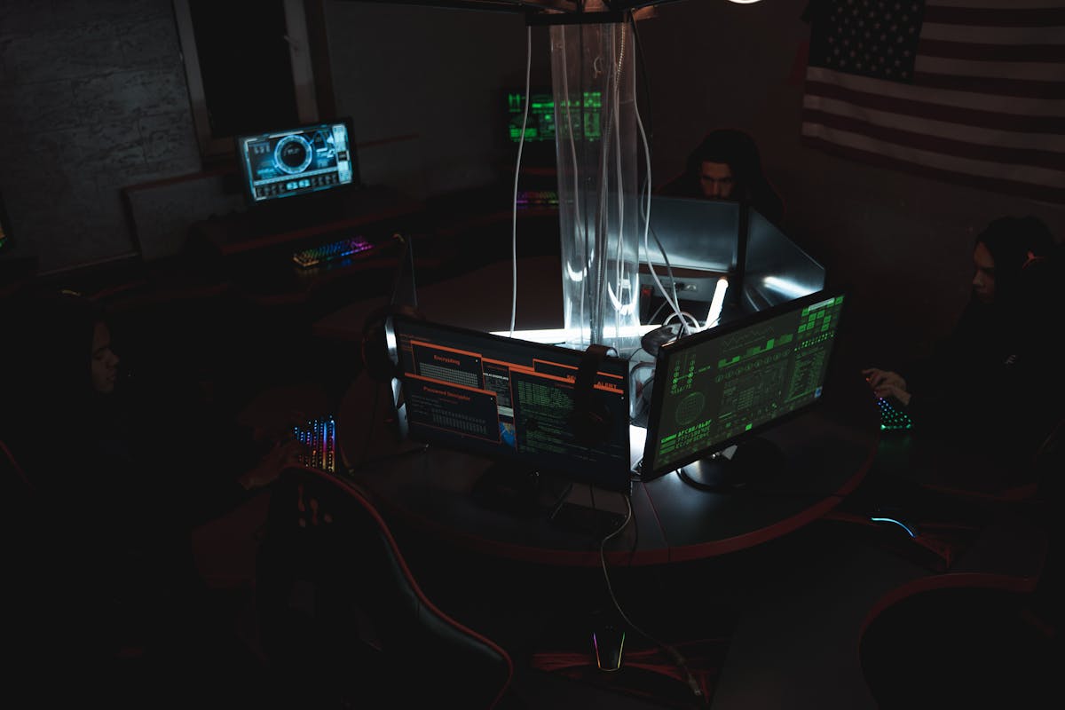 Team di esperti cybersecurity al lavoro su computer in una stanza buia