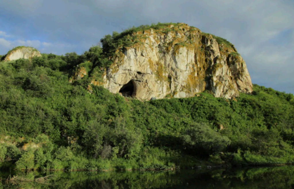Ingresso della grotta di Chagyrskaya in ambiente roccioso e vegetazione