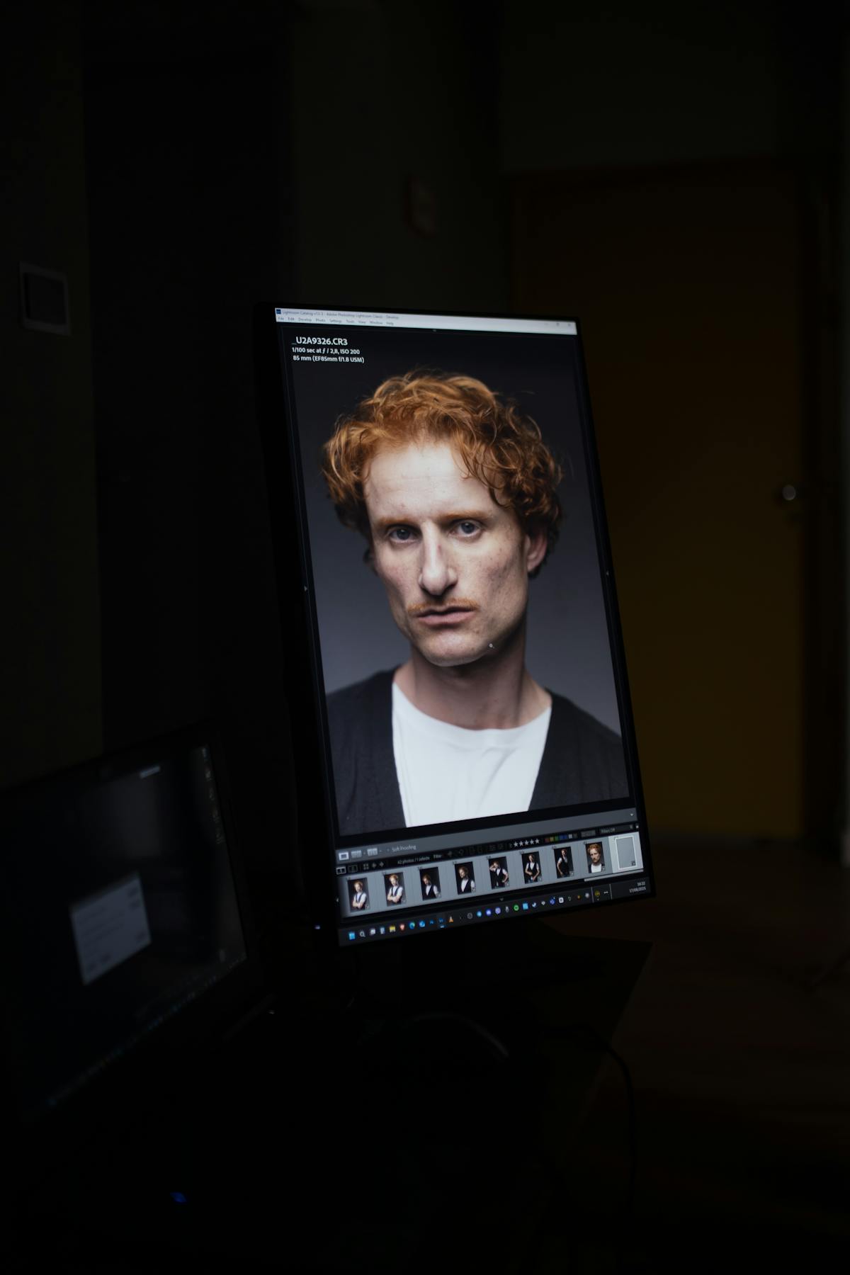 Ritratto in editing su un monitor in una stanza in penombra