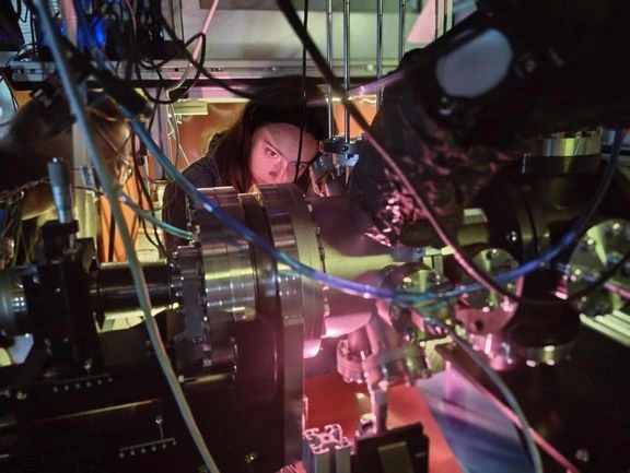 Una ricercatrice della TU Wien regola il laser dietro la camera a vuoto con il cristallo di torio