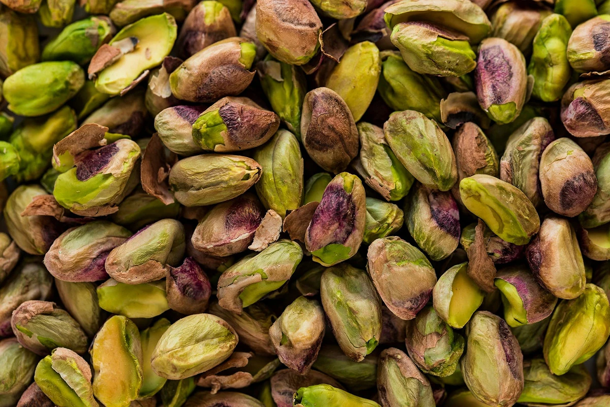 Pistacchi sgusciati verdi e viola in primo piano